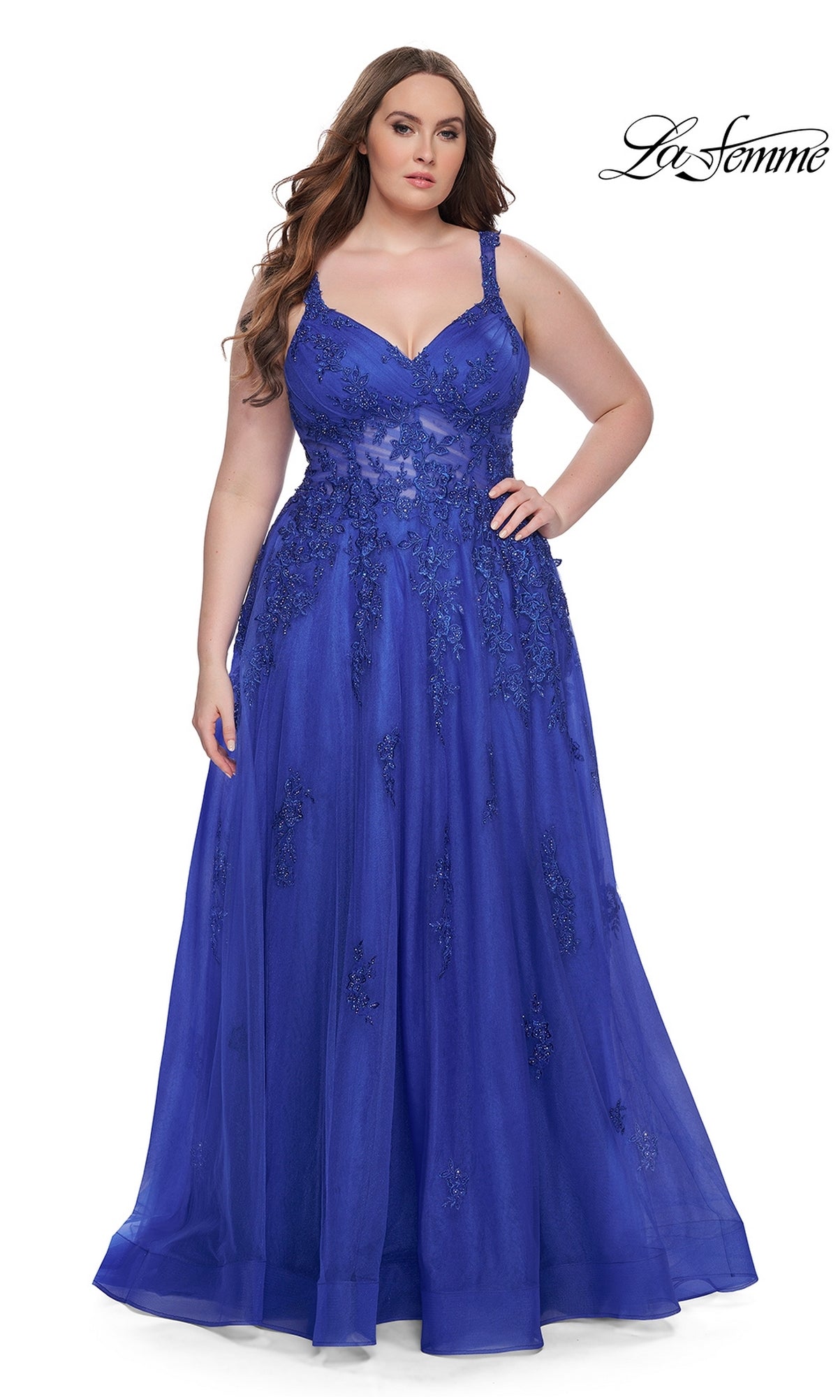 A woman wears the La Femme Long Prom Dress 31383, a sleeveless, floor-length royal blue embroidered lace gown with floral details, standing against a plain white background. The La Femme logo appears in the top right corner.